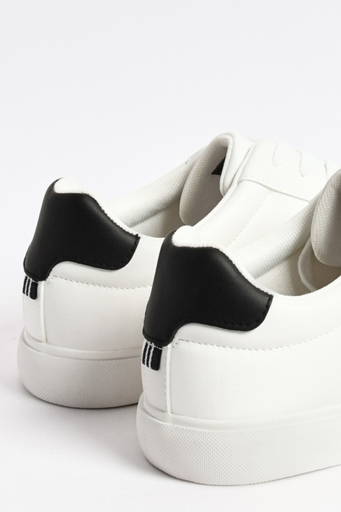 Tenis blancos casuales con contraste negro y perforaciones
