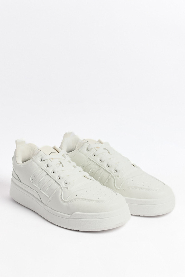Tenis blancos casuales con suelas planas y perforaciones