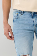 Jean azul claro tipo skinny tiro bajo con desgastes sutiles