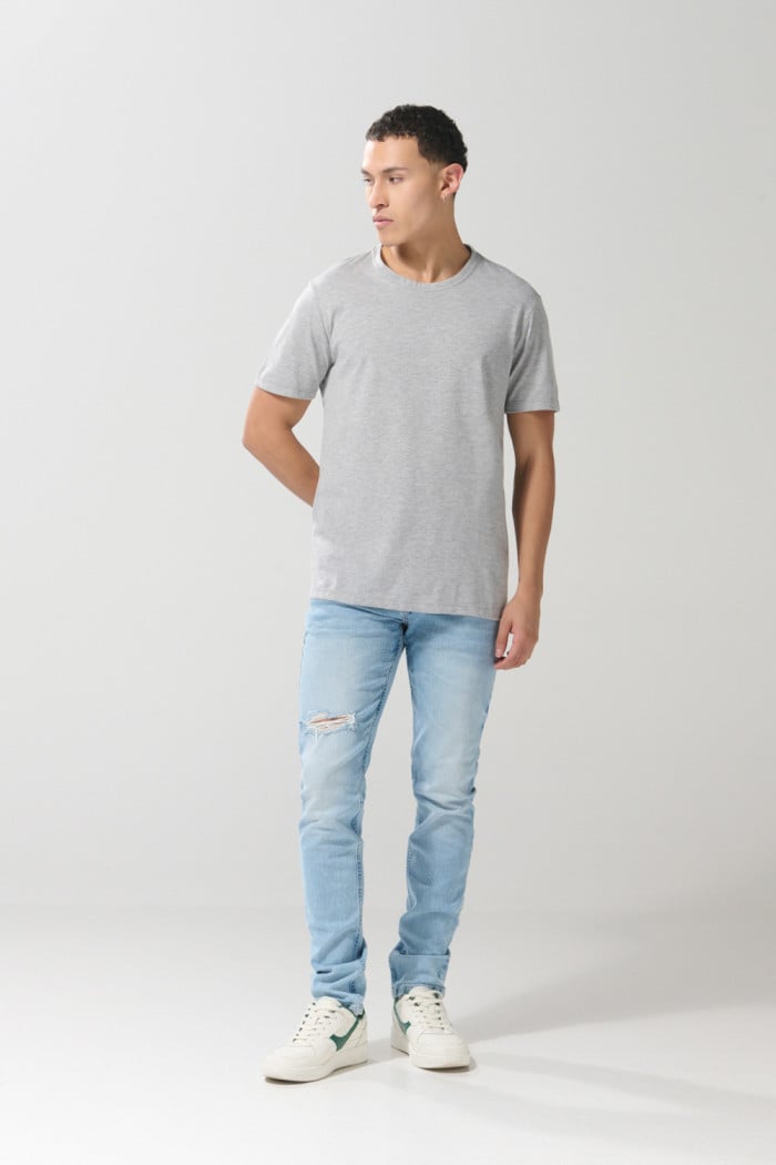 Jean azul claro skinny con desgastes localizados y tiro bajo