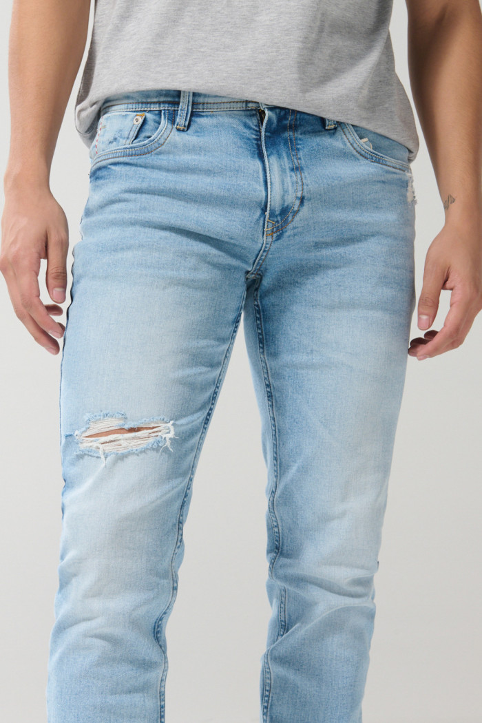 Jean azul claro skinny con desgastes localizados y tiro bajo