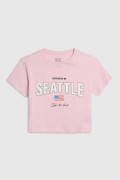 Camiseta crop top rosada con diseño college en frente