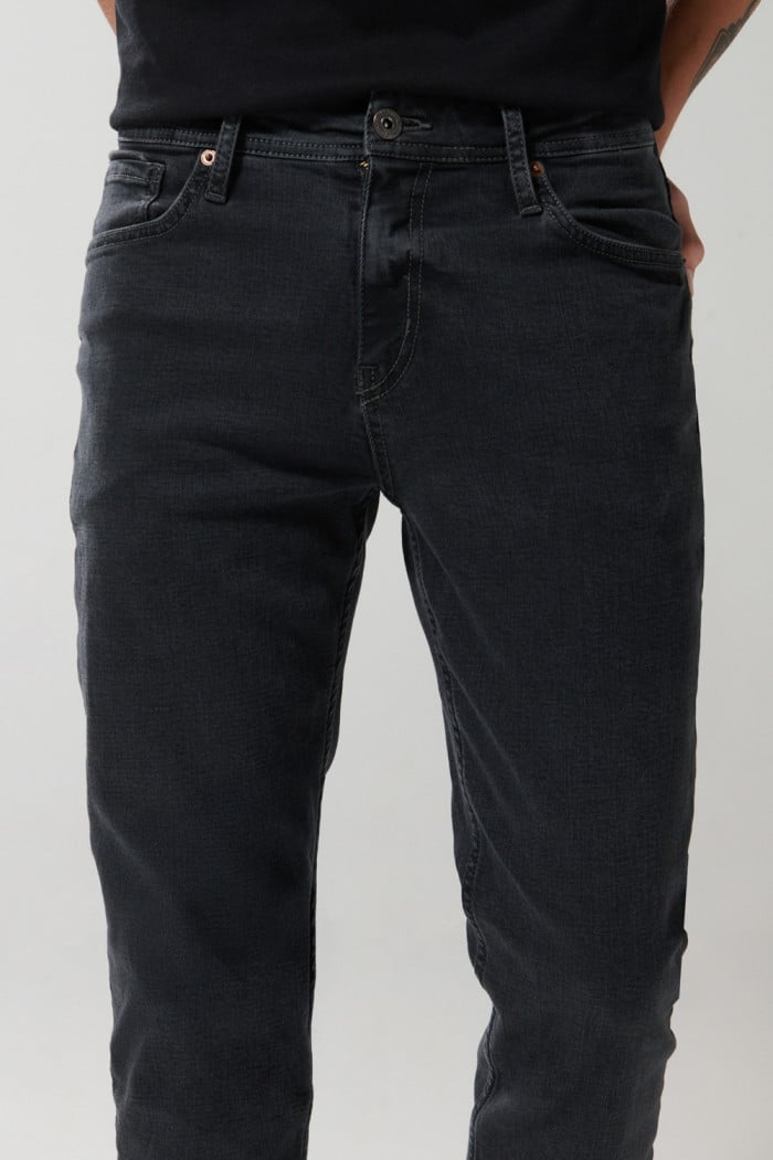 Jean slim gris oscuro tiro bajo con ligeros desgastes