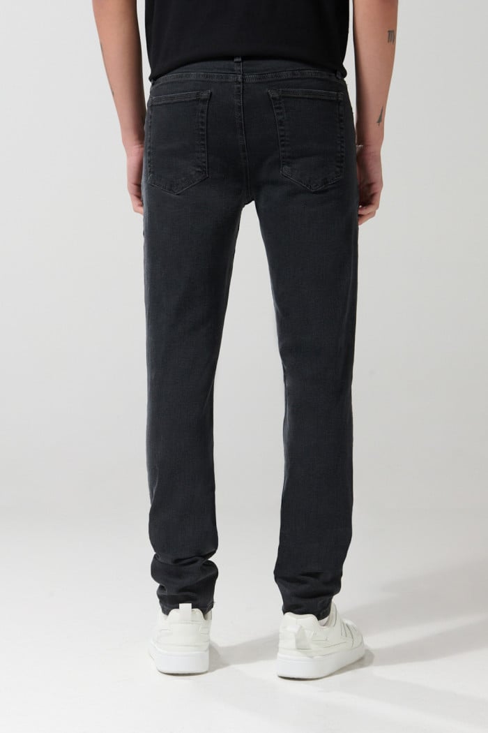 Jean slim gris oscuro tiro bajo con ligeros desgastes