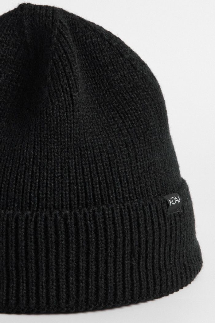 Gorro negro tejido con marquilla decorativa y doblez
