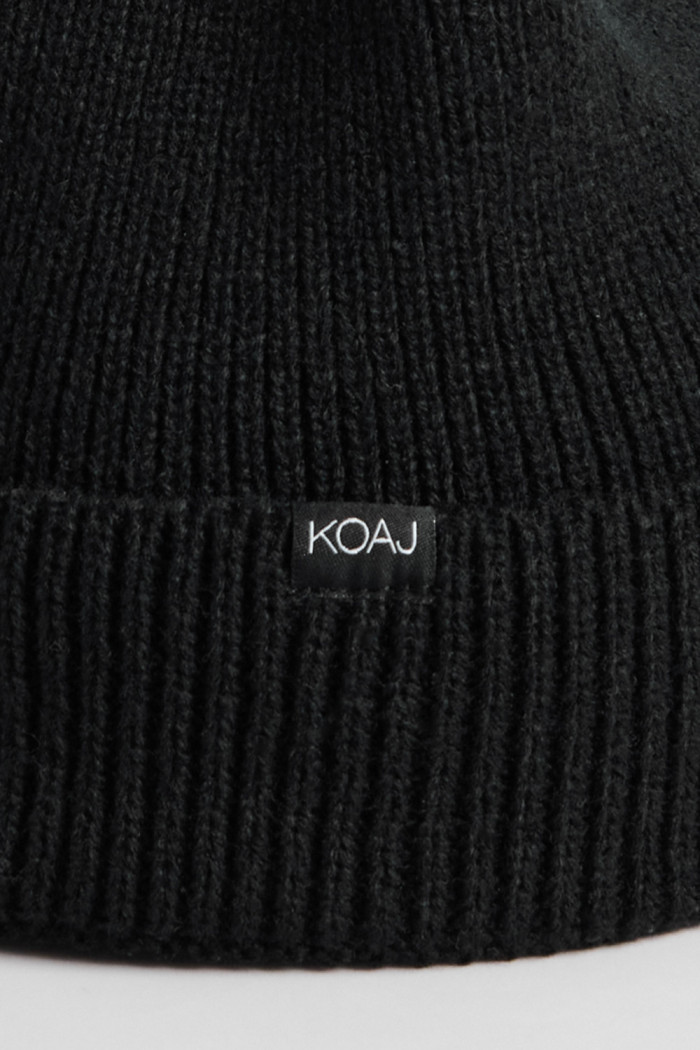 Gorro negro tejido con marquilla decorativa y doblez
