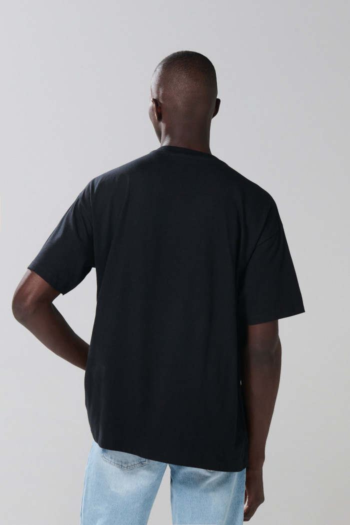 Camiseta negra oversize cuello redondo con arte de playa