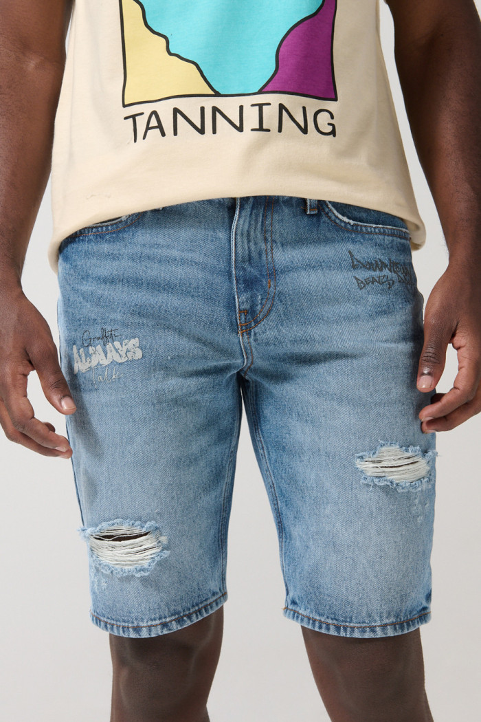 Bermuda slim tiro bajo en jean azul con rotos y diseños