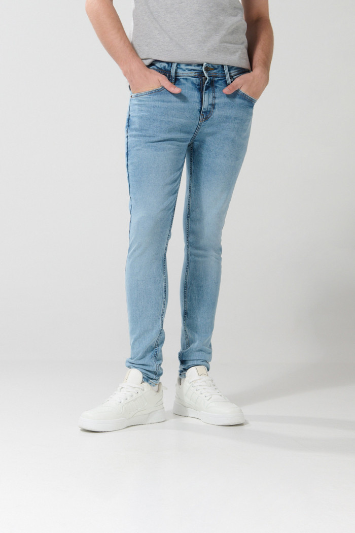 Jean súper skinny azul con desgastes sutiles y tiro bajo