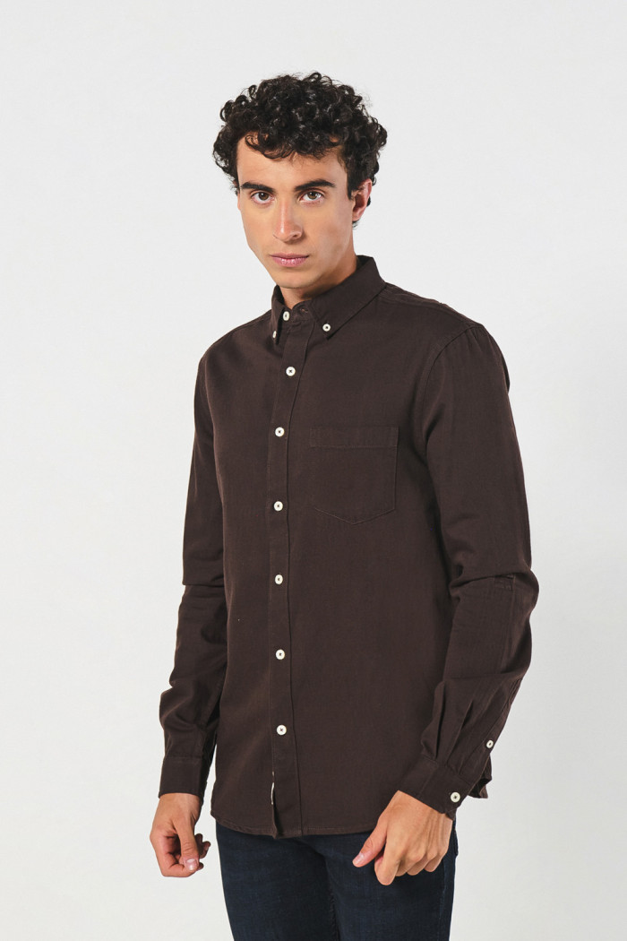 Camisa unicolor con cuello button down y bolsillo en frente