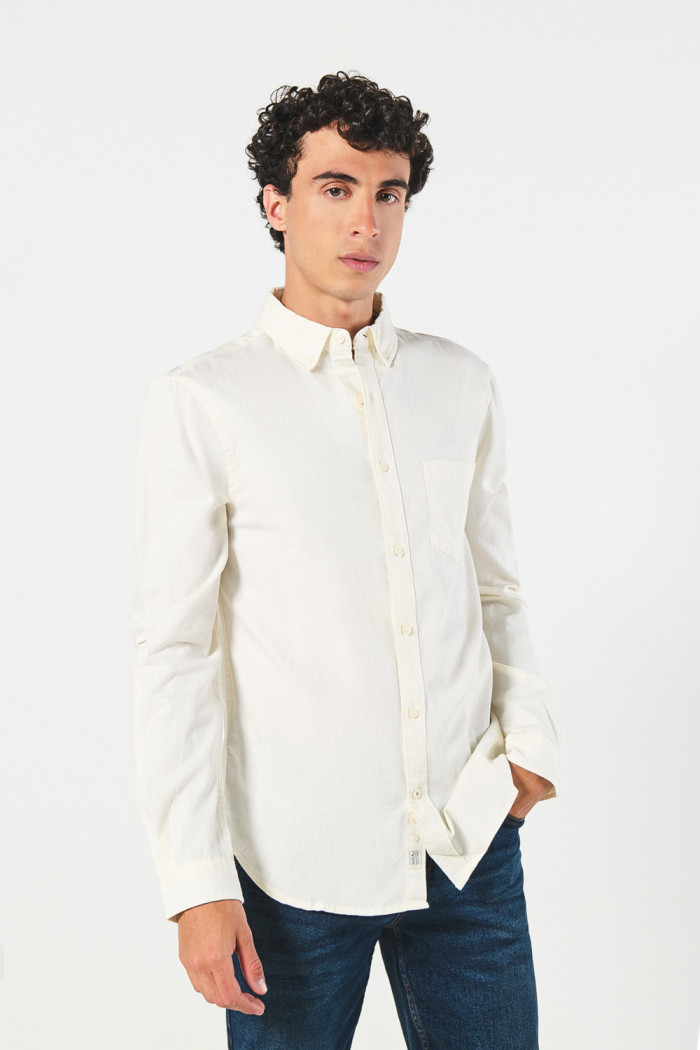 Camisa unicolor con cuello button down y bolsillo en frente