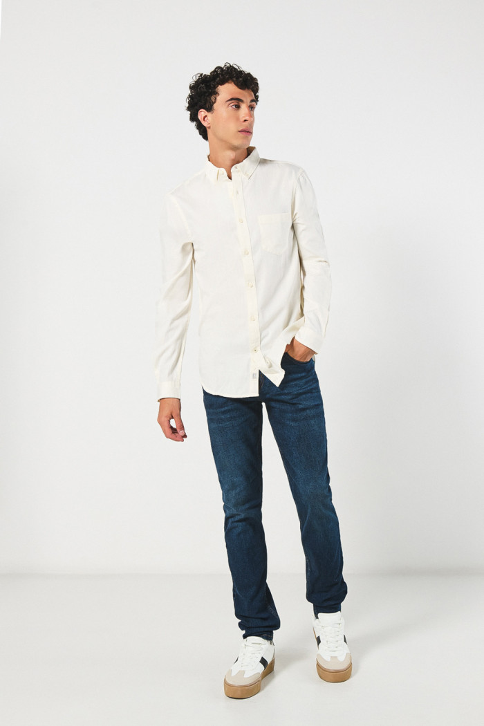 Camisa unicolor con cuello button down y bolsillo en frente