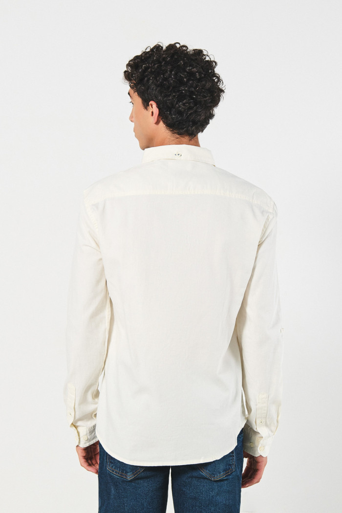 Camisa unicolor con cuello button down y bolsillo en frente