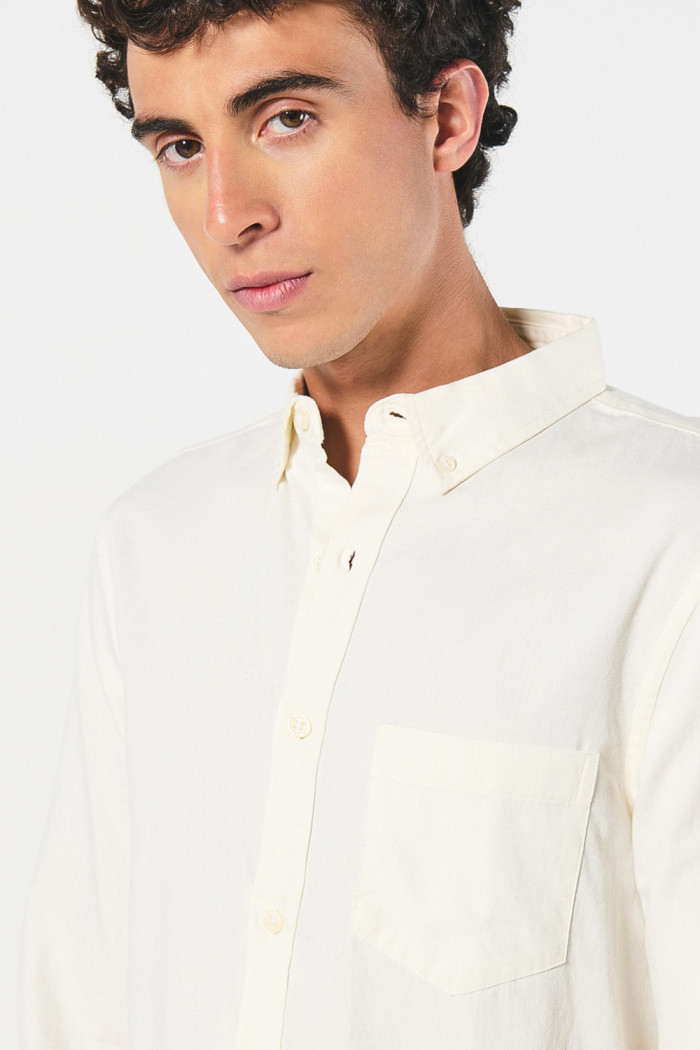 Camisa unicolor con cuello button down y bolsillo en frente