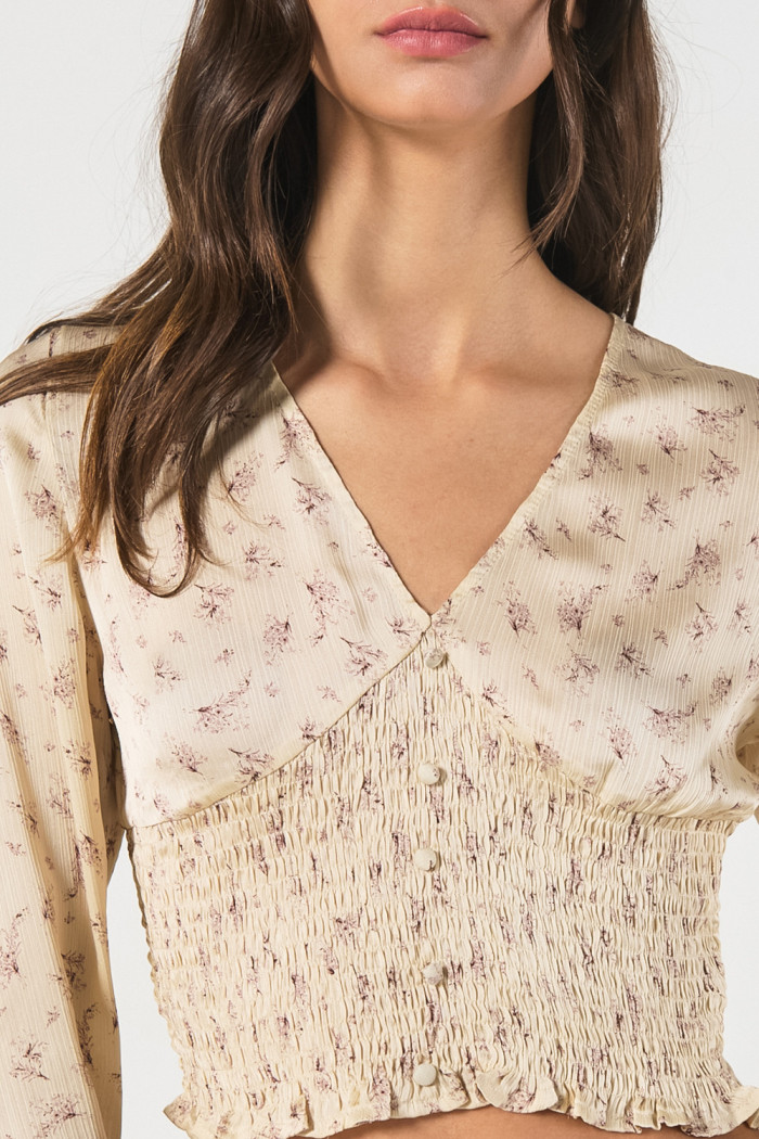 Blusa crop top crema estampada con manga larga y escote V