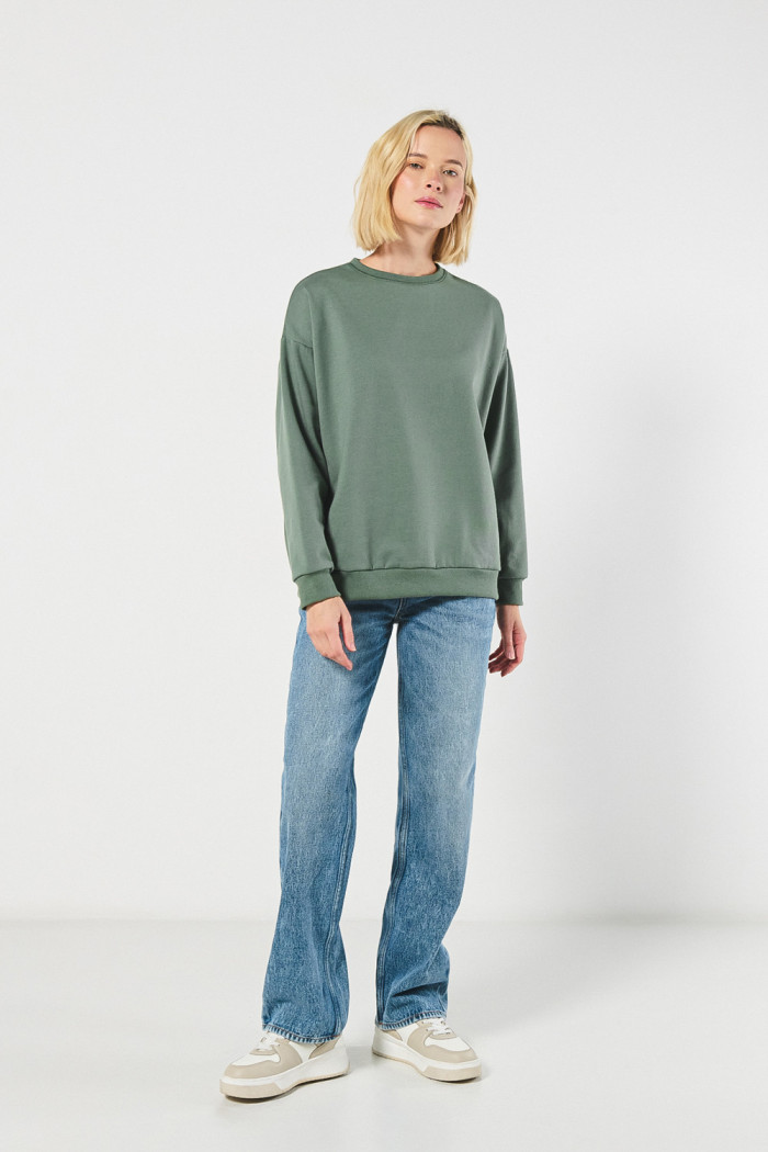 Buzo unicolor cuello redondo oversize con hombro caído