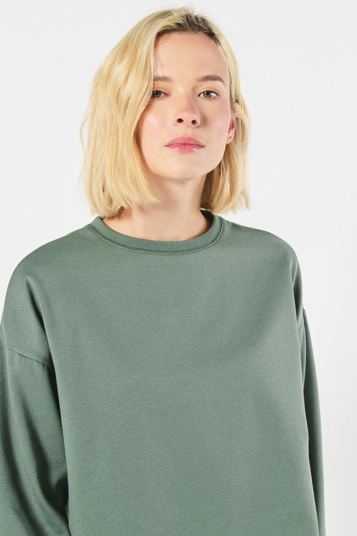 Buzo unicolor cuello redondo oversize con hombro caído
