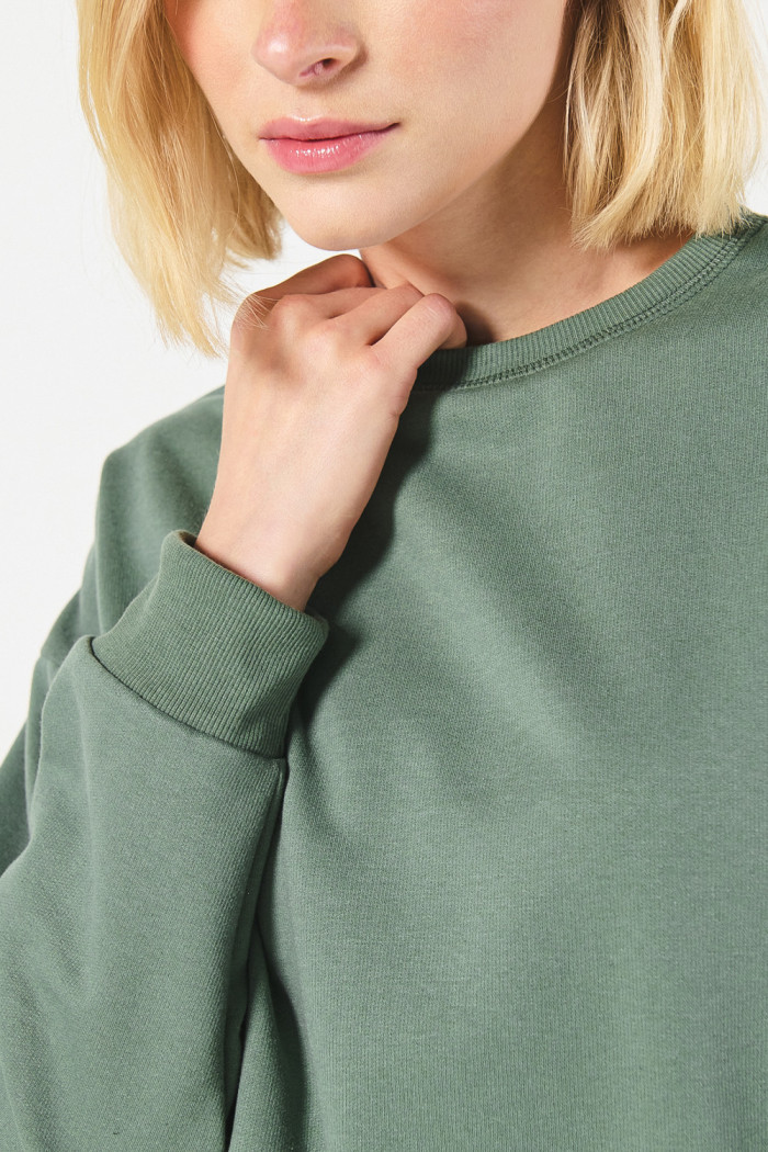 Buzo unicolor cuello redondo oversize con hombro caído