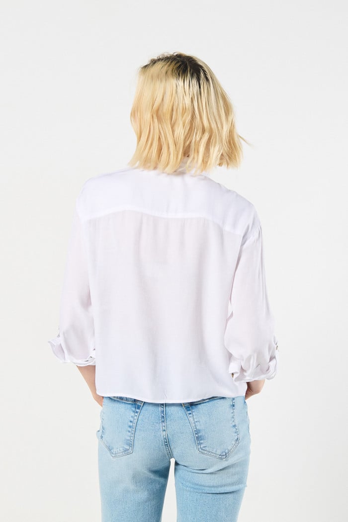 Blusa unicolor con cuello camisero y doble bolsillo en frente
