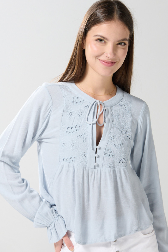 Blusa unicolor manga larga con diseños bordados en frente