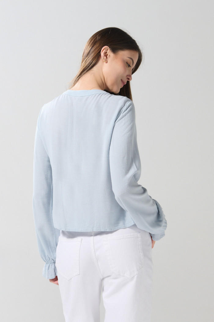 Blusa unicolor manga larga con diseños bordados en frente