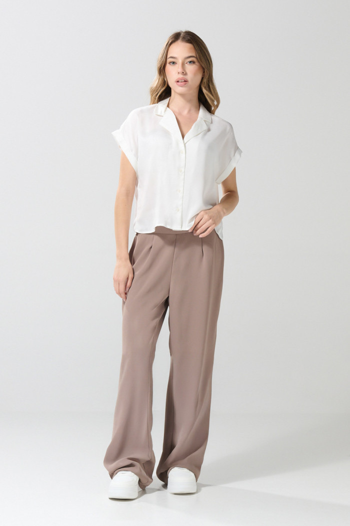 Blusa unicolor con manga corta, hombro rodado y botones