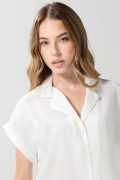 Blusa unicolor con manga corta, hombro rodado y botones