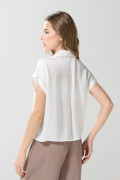 Blusa unicolor con manga corta, hombro rodado y botones