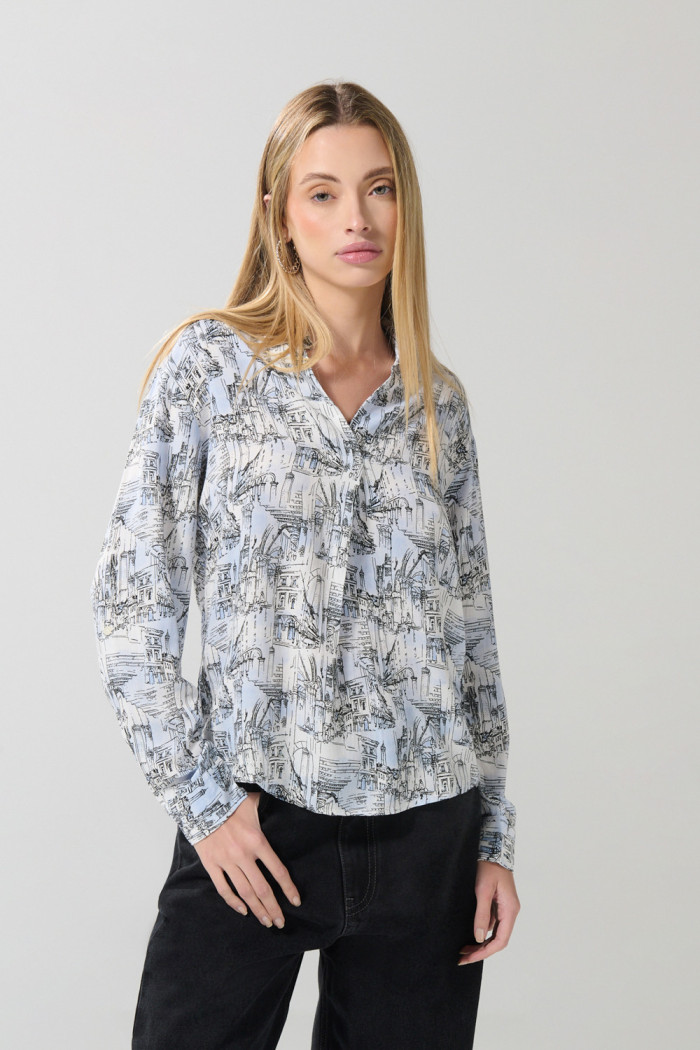 Blusa crema clara con diseños estampados y manga larga
