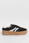 Tenis casuales negros con suelas altas planas y contrastes