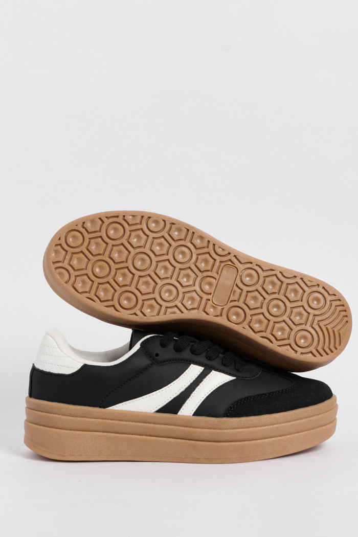 Tenis casuales negros con suelas altas planas y contrastes