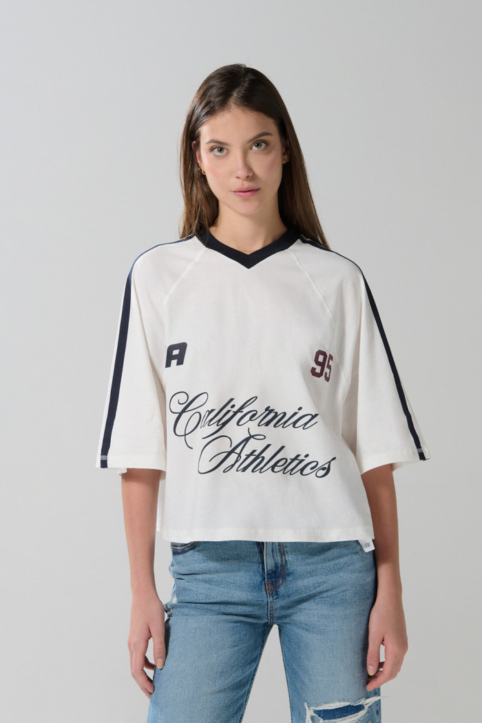 Camiseta crop top crema college oversize con cuello V