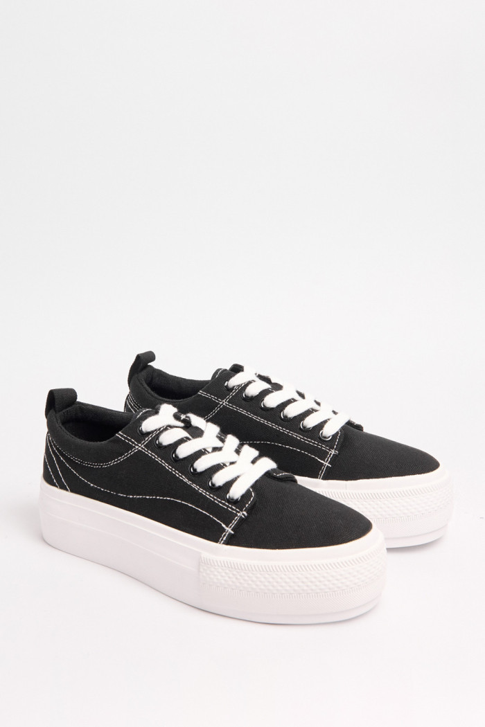 Tenis negros casuales de plataforma con costuras blancas