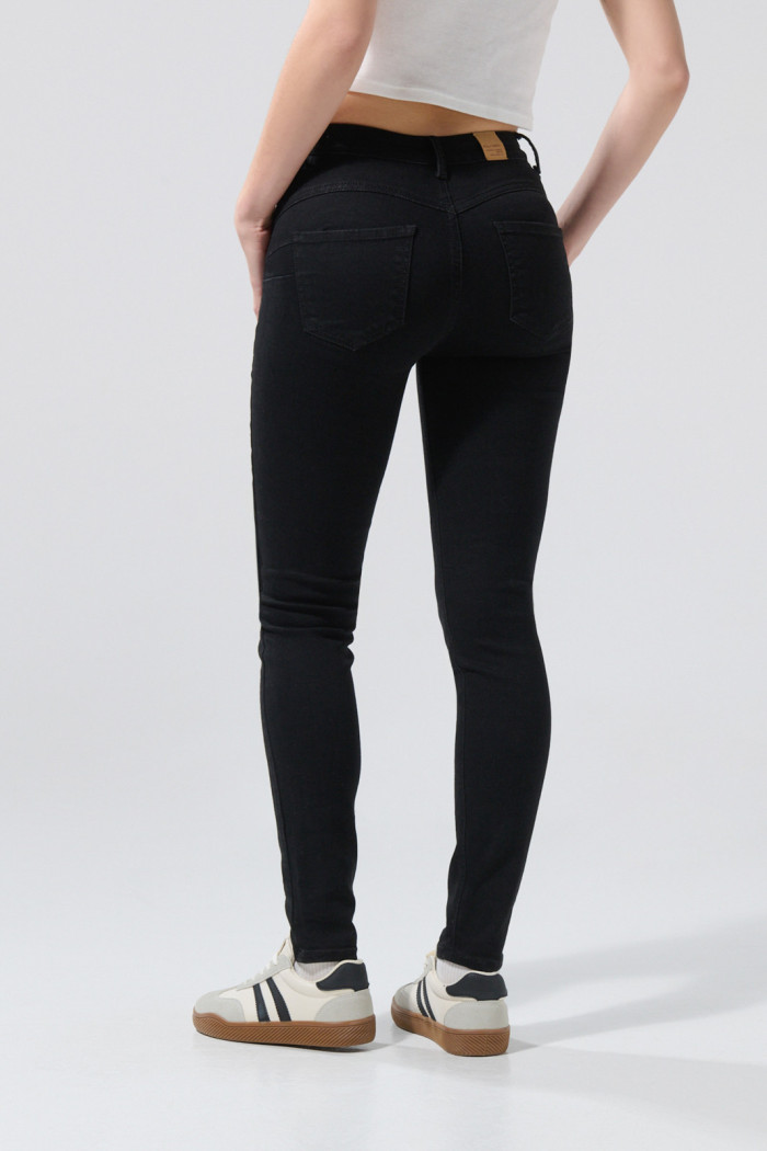 Jean push up tiro alto negro con realce posterior y bolsillos