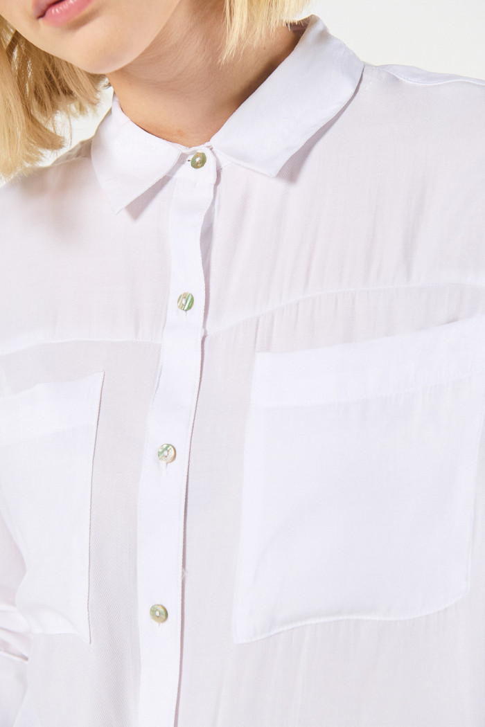 Blusa unicolor con cuello camisero y doble bolsillo en frente