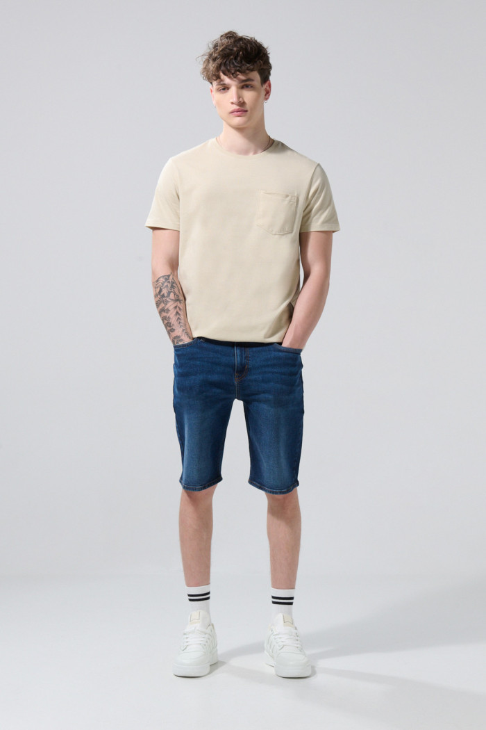 Bermuda de jean slim azul oscura con tiro bajo y bolsillos