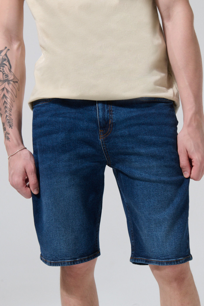 Bermuda de jean slim azul oscura con tiro bajo y bolsillos