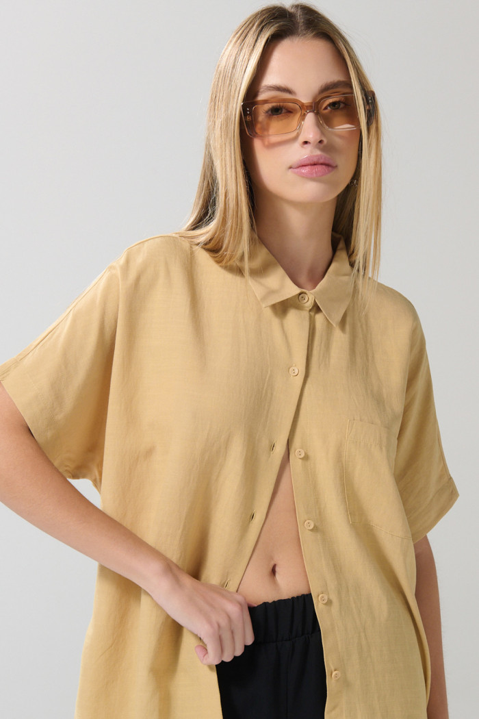 Blusa unicolor con cuello camisero y hombro rodado