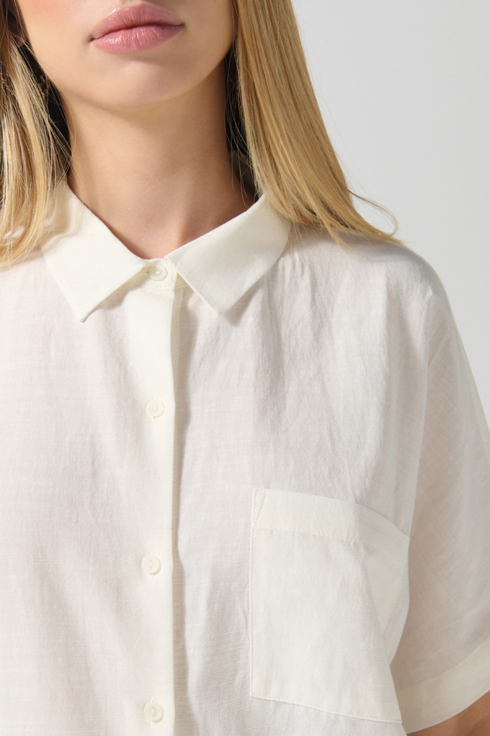 Blusa unicolor con cuello camisero y hombro rodado