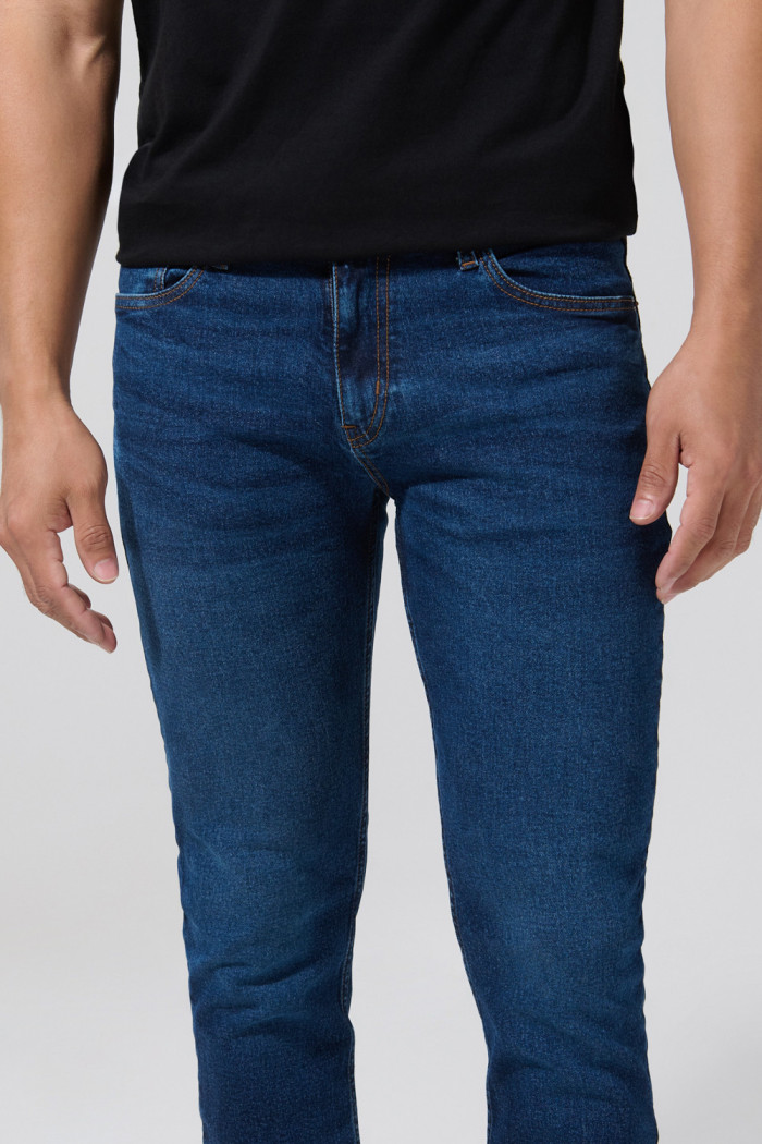 Jean azul slim con bolsillos, tiro bajo y desgastes