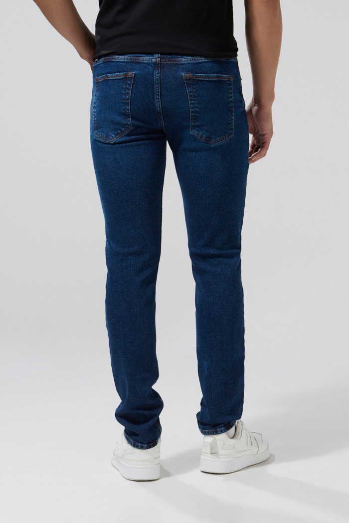 Jean azul slim con bolsillos, tiro bajo y desgastes