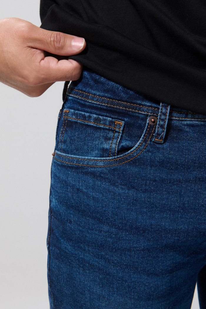 Jean azul slim con bolsillos, tiro bajo y desgastes