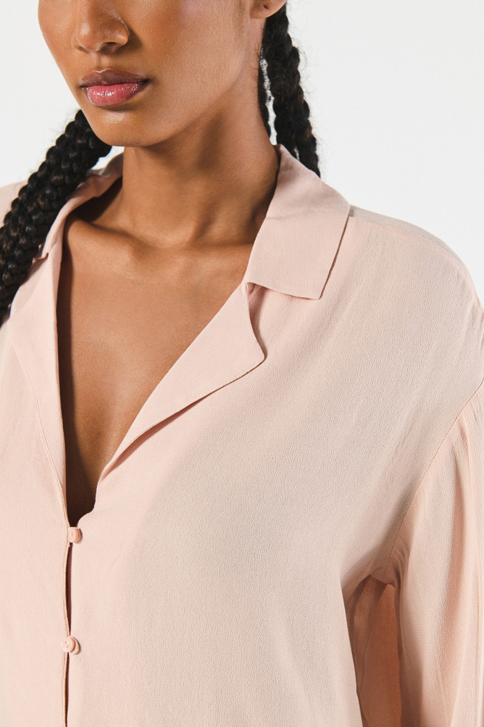 Blusa unicolor cuello resort con manga larga y botones