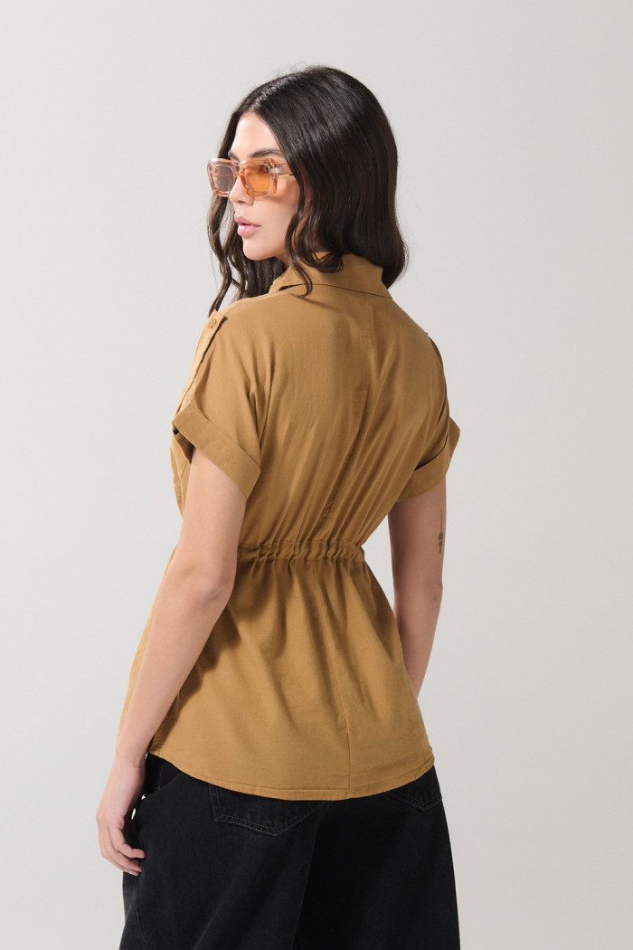 Blusa café clara con manga corta, charreteras y bolsillo