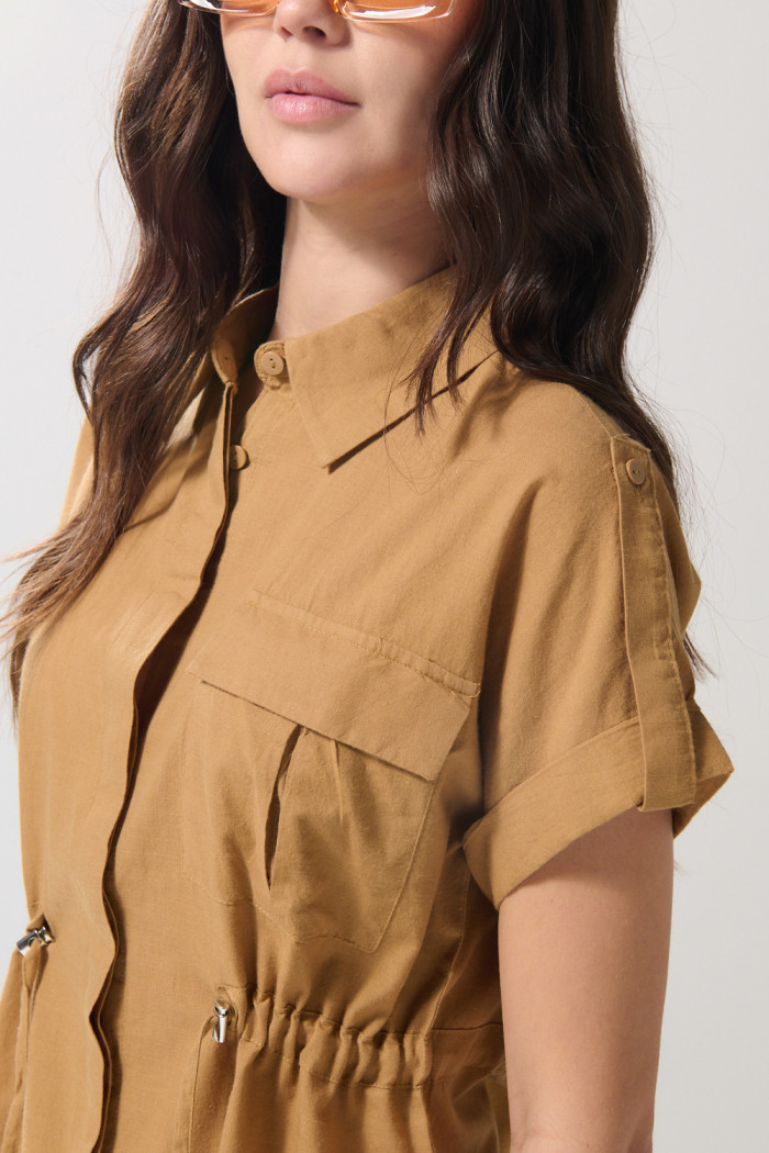 Blusa café clara con manga corta, charreteras y bolsillo